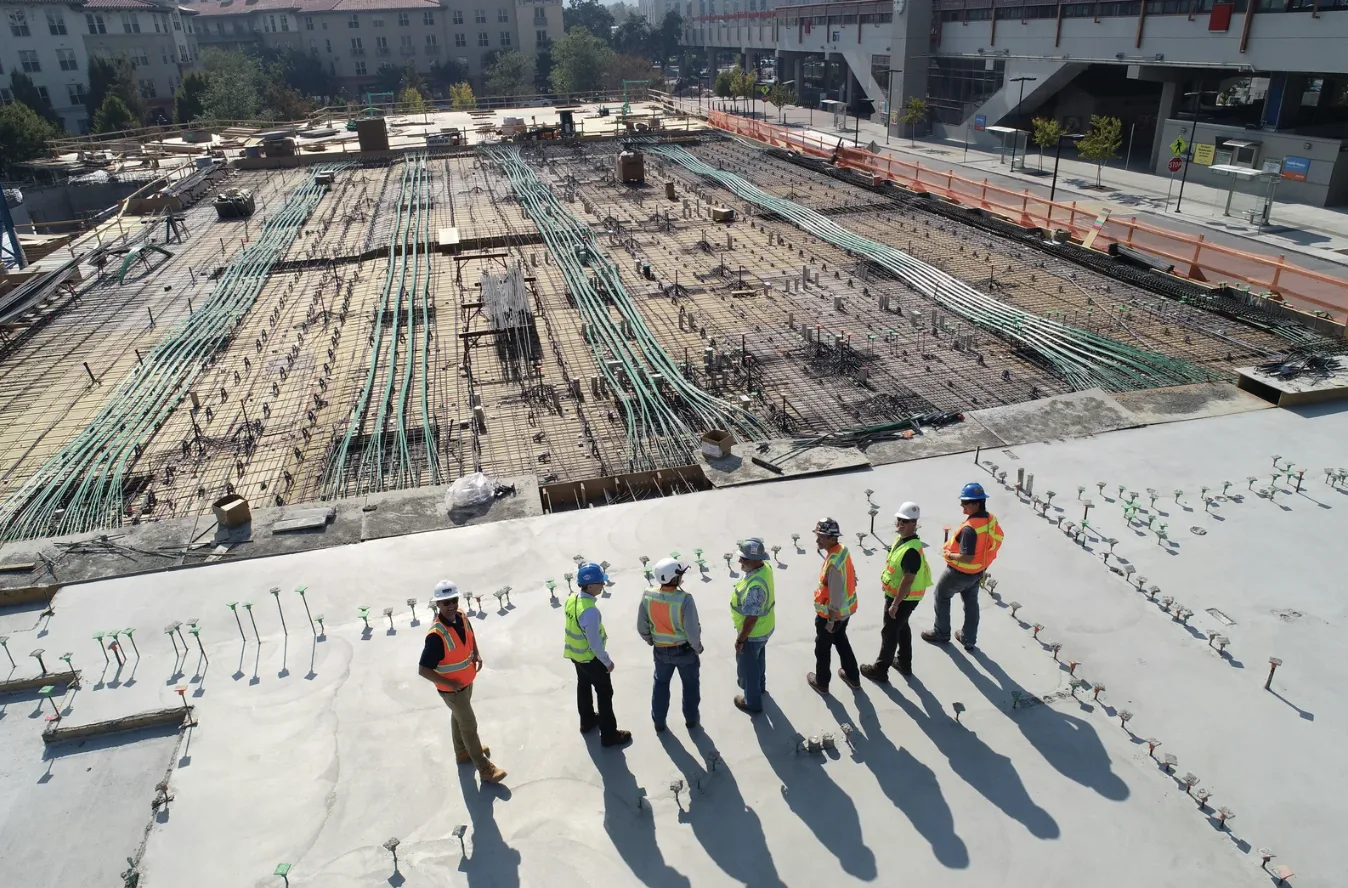 Construction crew in hi-vis on a concrete deck above a reinforced slab under construction